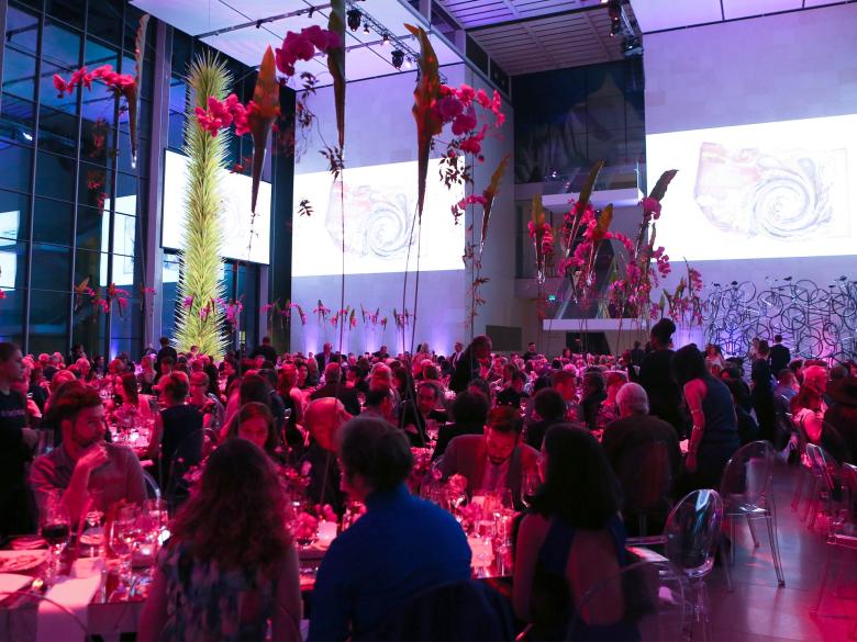 A sit-down event takes place at night in Shapiro Family Courtyard 