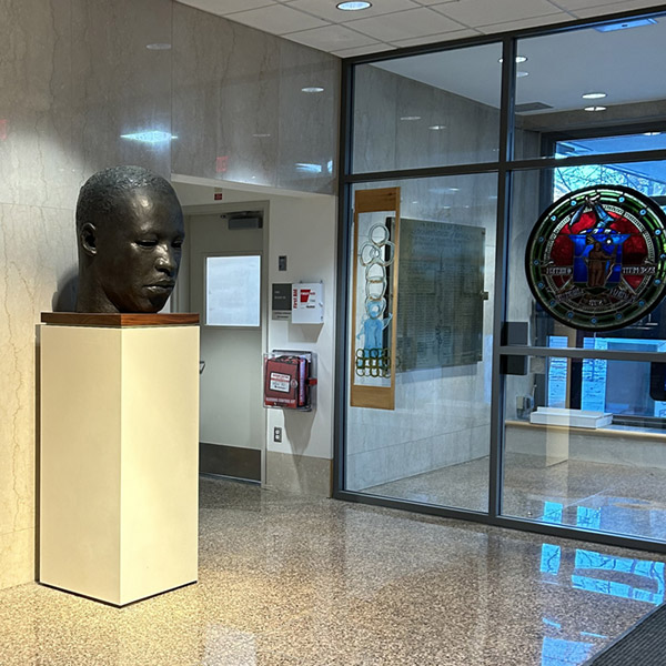 A bust of Dr. Martin Luther King Jr. sits on a pedestal in a government building lobby.