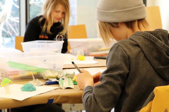 Two children creating clay sculptures. 