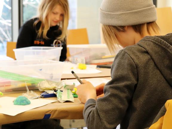 Two children creating clay sculptures. 