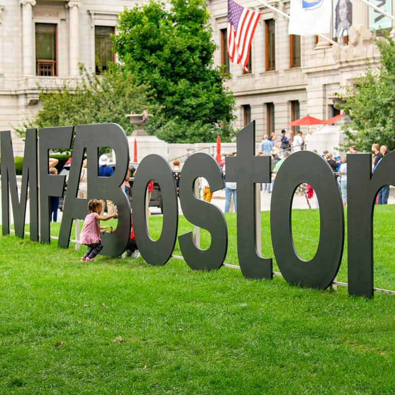 Visitors explore the MFABoston logo sign on the Huntington lawn