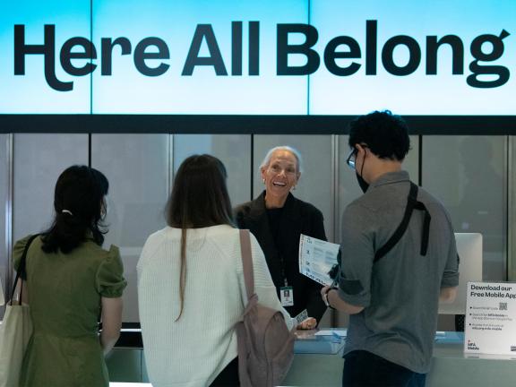 An MFA staff member talking to three visitors at the Sharf Visitor Center.