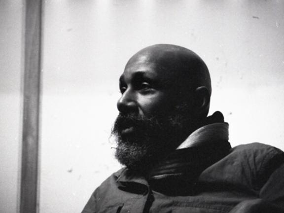 Black-and-white photo of a bearded man in dramatic light.