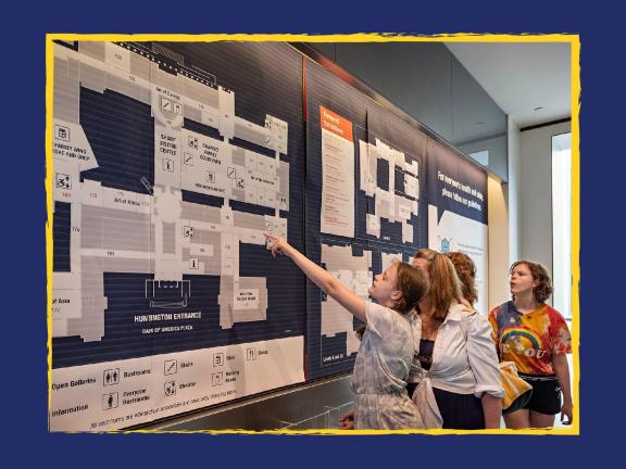 Four visitors looking at large wall map in Sharf Visitor Center