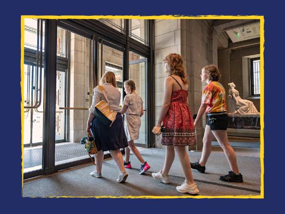 Four visitors exiting the Museum through the doors at the entrance