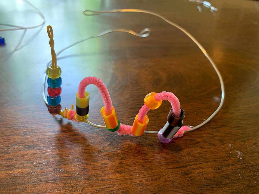 adding more pipe cleaners with beads along the wire crown