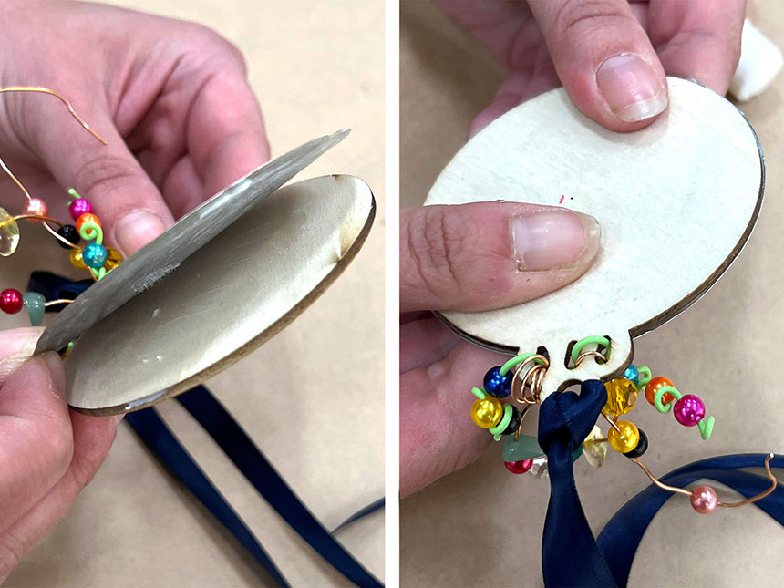 pressing embossed foil circle onto cardboard pendant