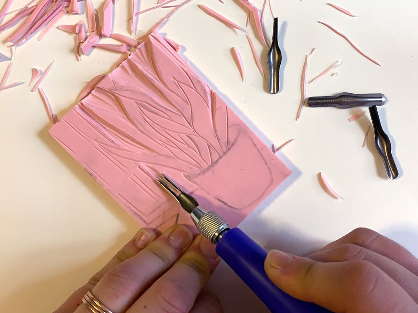 Using linoleum cutter to carve image into block