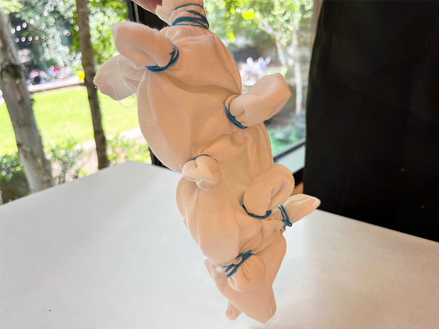 white cloth bundled up with rubber bands forming protrusions throughout