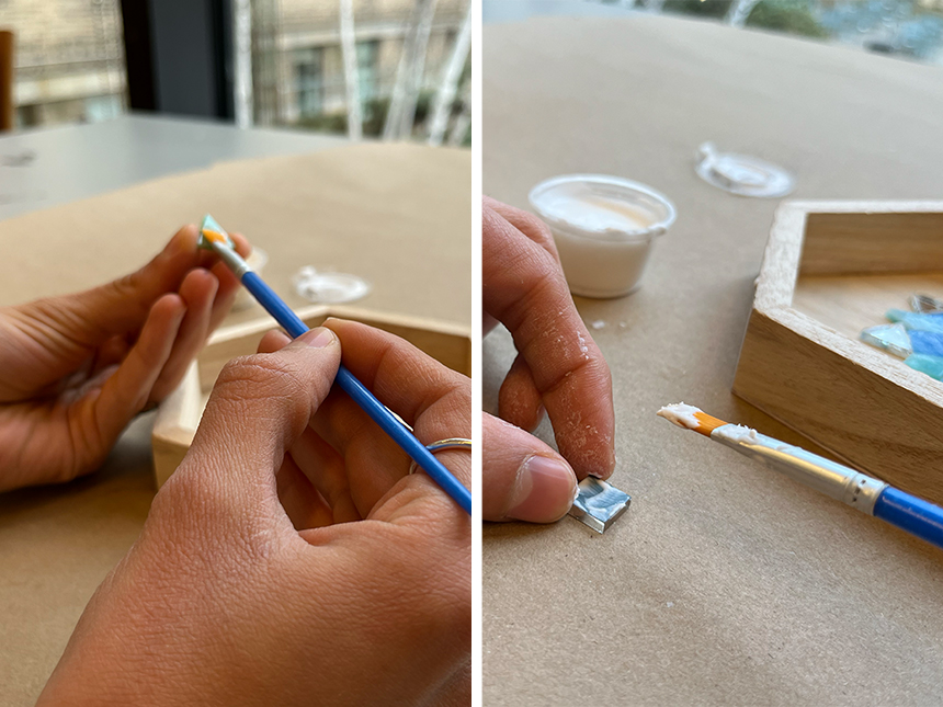 using paintbrush to apply glue onto one side of mosaic tile