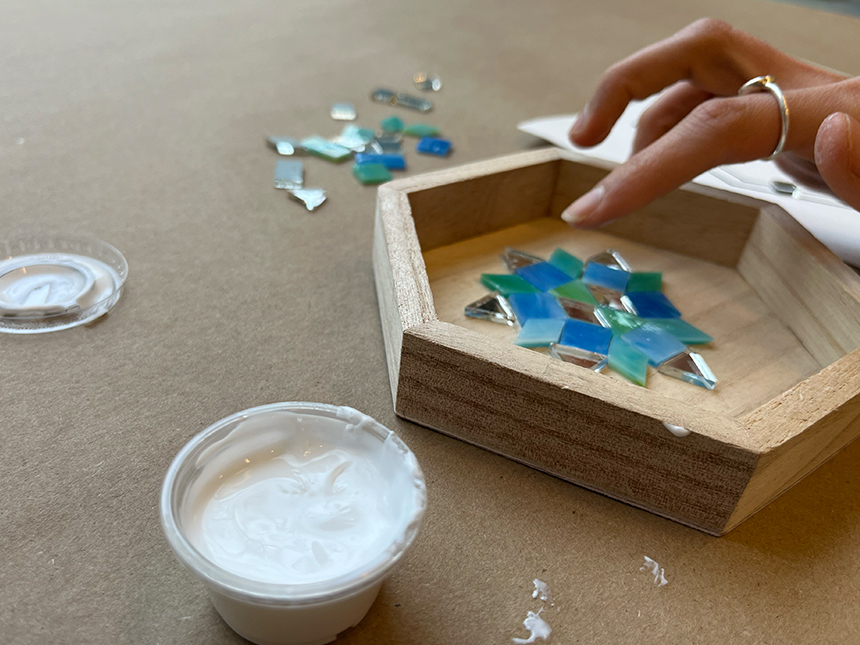 pressing down on mosaic tiles arranged in box