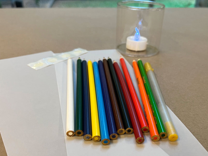 various colored pencils laid out on top of paper