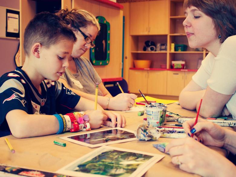 kid in Patriots shirt drawing in hospital