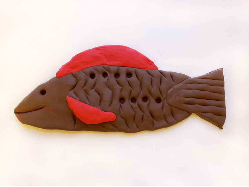 smiling clay fish with tail, scales and fins