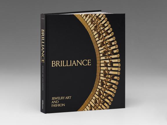 Image of book cover for Brilliance: Jewelry Art and Fashion, featuring a gold floral necklace swooping across a black background
