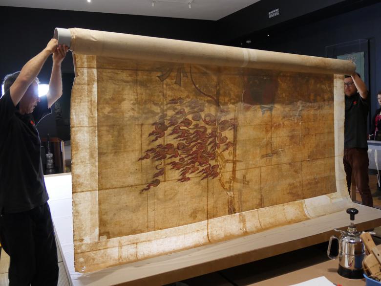 Conservators moving an oversized Chinese painting