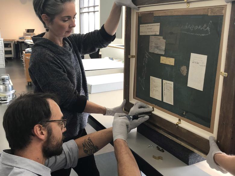 A French pastel being secured into its custom frame