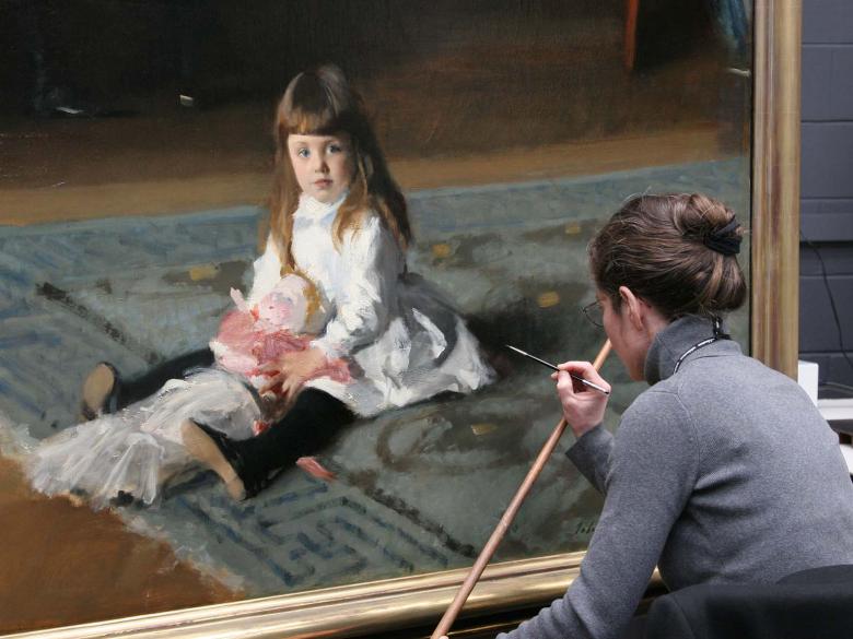 Conservator treating a painting