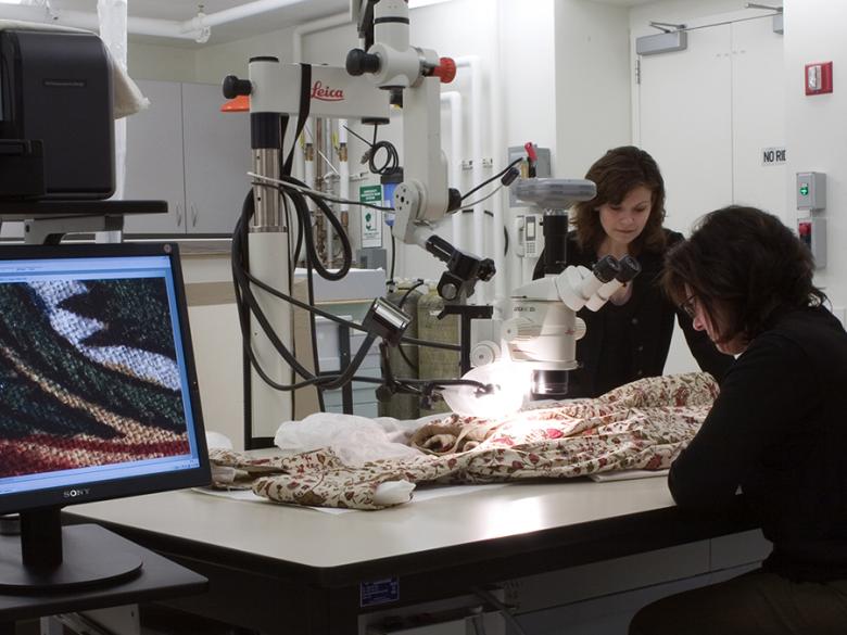 Conservators examining an Indian cotton dress