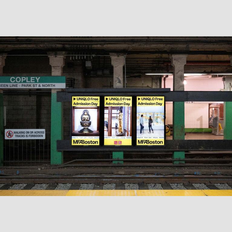Triptych of three digital ads visible across trolley tracks at Copley station