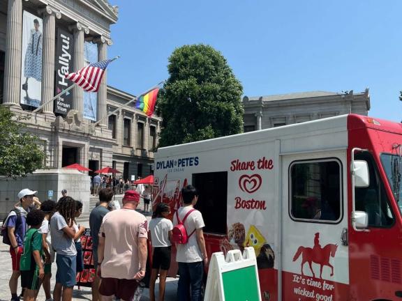 Citizens logo on sandwich sign in front of ice cream truck distributing treats to line of visitors outside Museum's Huntington Avenue Entrance