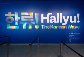"Hallyu! The Korean Wave" in large metallic letters and Korean characters on wall at exhibition entrance