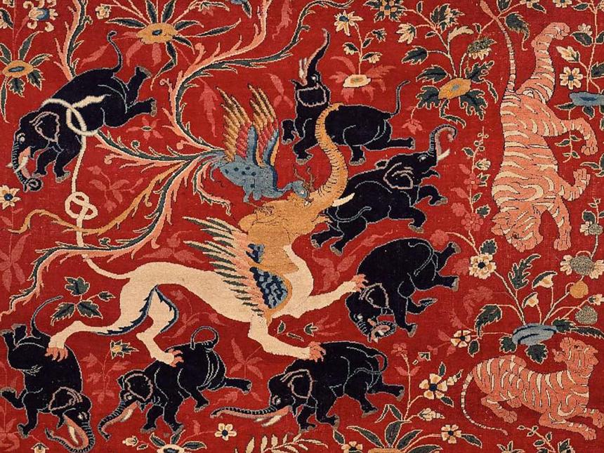 detail of pictorial carpet depicting numerous black elephants and tigers surrounding phoenix and an elephant-headed chimera-like creature