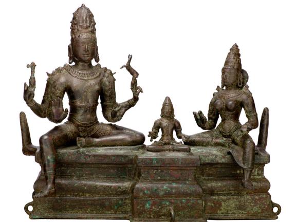 A statue of Hindu God Shiva sitting with his wife Uma and son Skanda