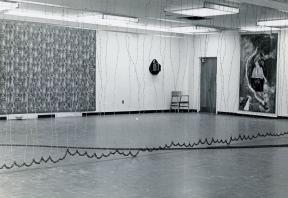 The "5+1" gallery space is split by a barbed wire curtain.