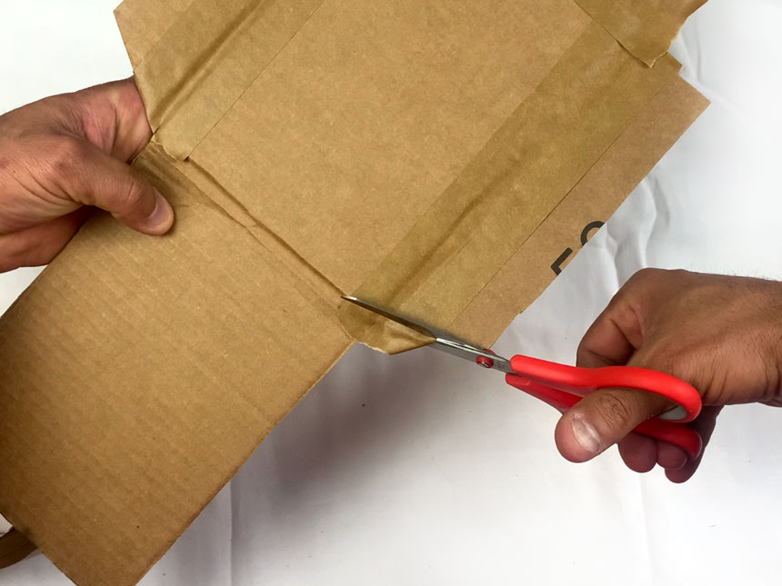 using scissors to cut off excess tape from the attached flaps
