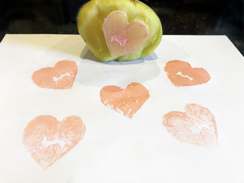 numerous heart prints on paper, with potato heart stamp adjacent