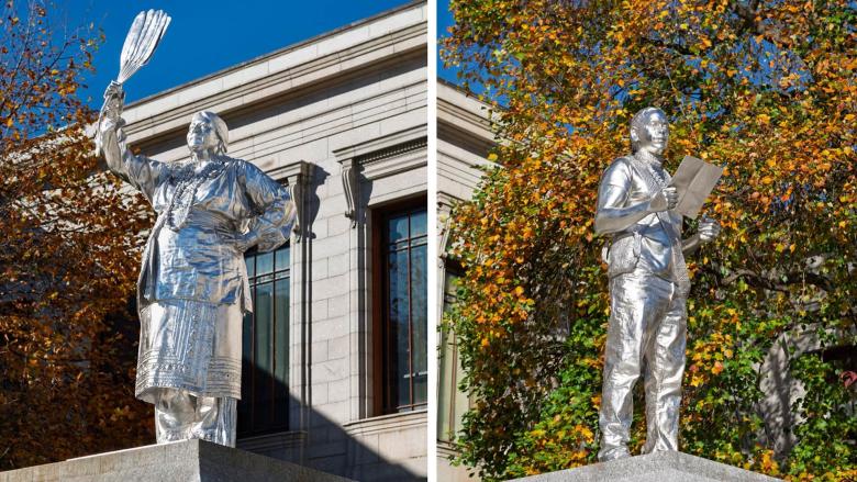 At left, a silver sculpture of Julia Marden in traditional regalia holding up fan made of turkey feathers; at right, a silver sculpture of Andre StrongBearHeart Gaines Jr. reading from piece of paper.