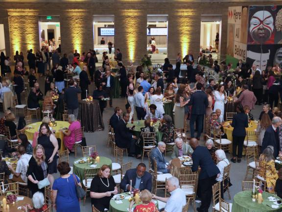 Large, bustling reception with guests mingling at tables in Shapiro Family Courtyard