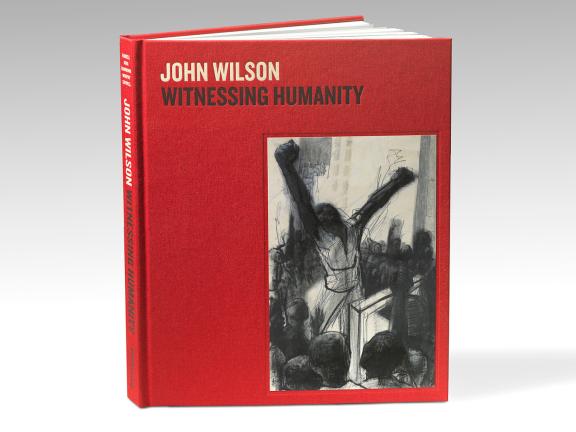 Image of book cover. John Wilson: Witnessing Humanity is stamped on red cloth. It features a charcoal drawing of a black figure stands with arms raised in front of a crowd.
