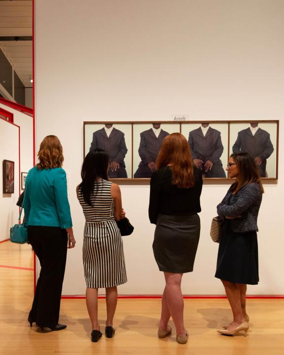 Four women looking at artwork