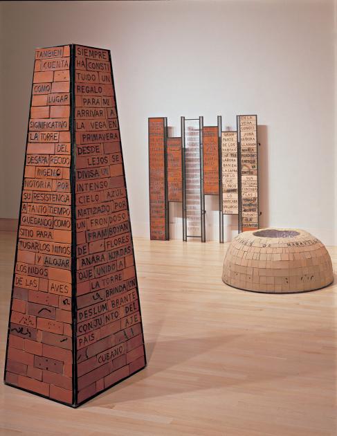 Brick obelisk, brick dome, and brick panels with writing in Spanish on them.