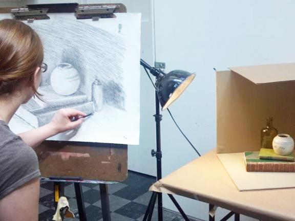 Student draws from still life in studio class