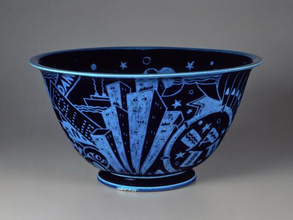 A glazed, black porcelain bowl is decorated with brilliant blue incised motifs of New York City attractions