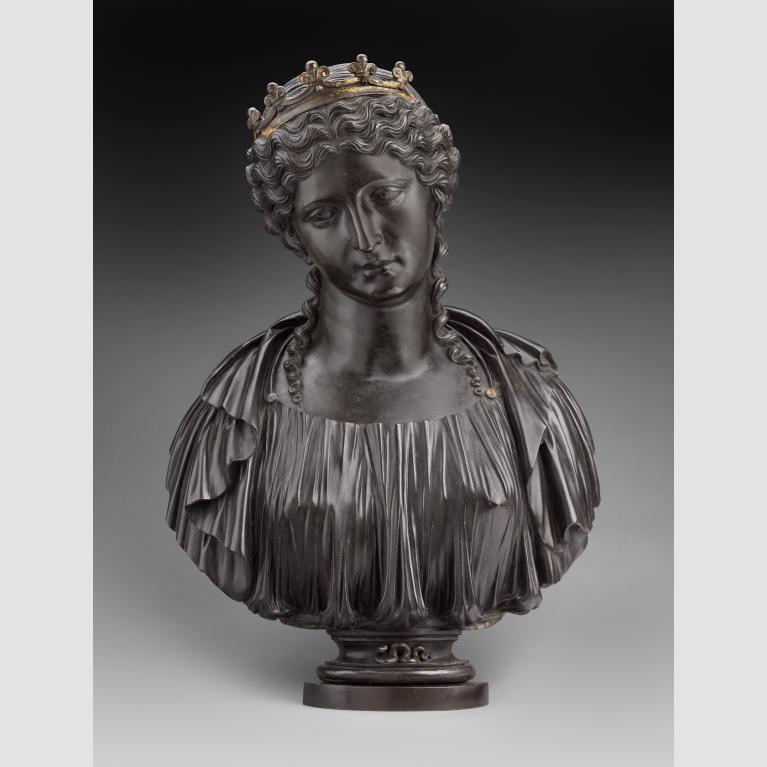 A dark metal bust of Cleopatra wearing a crown with a snake on the base.