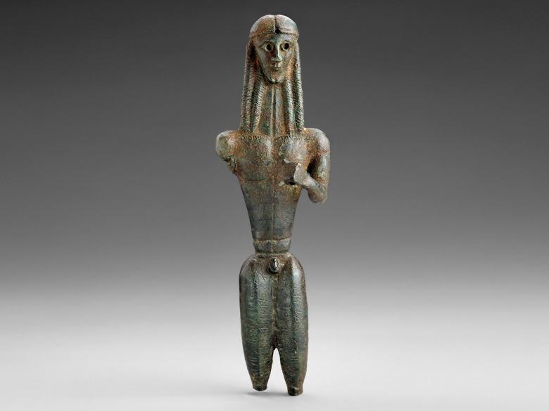 bronze figure of long-haired nude male standing; right arm broken off