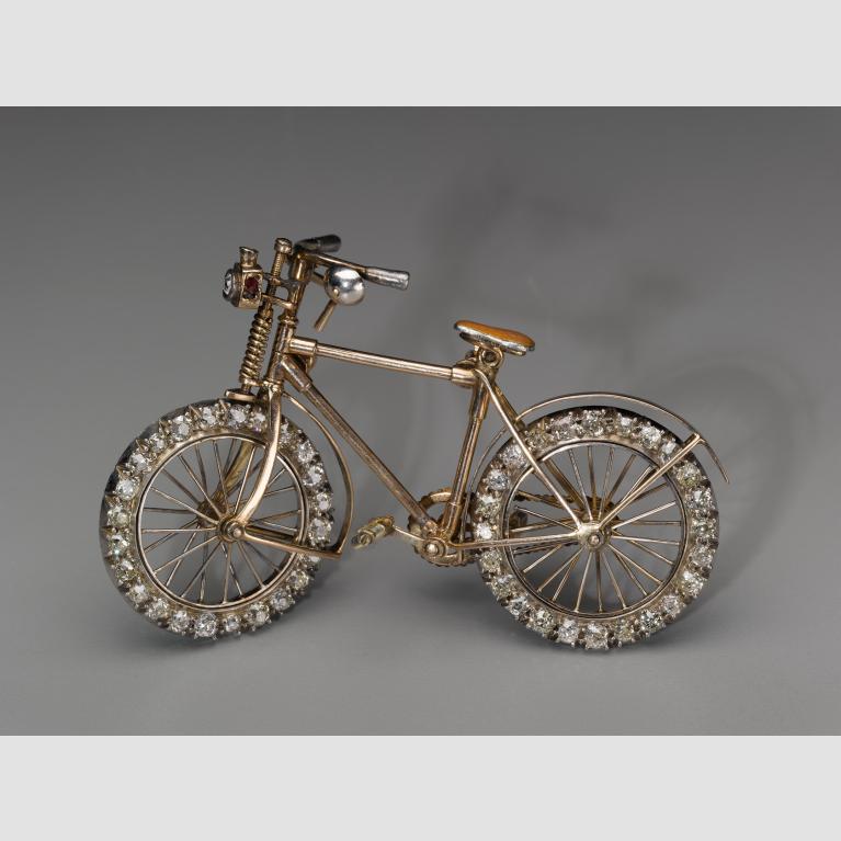 A small bicycle brooch with diamond-encrusted wheels.
