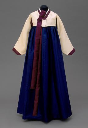 A traditional Hanbok gown with a white top and sleeves, a blue skirt, and red fabric details.