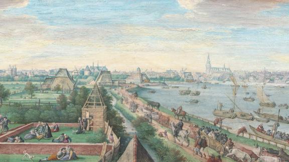 Painting depicting busy road and river filled with carts and boats; situated next to the river is a small town with a large cathedral in the background.