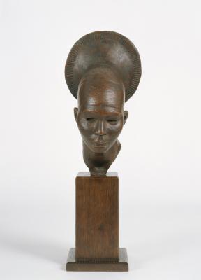 A brown, metallic-looking sculpture of a woman's head, headpiece, and neck on a wood base