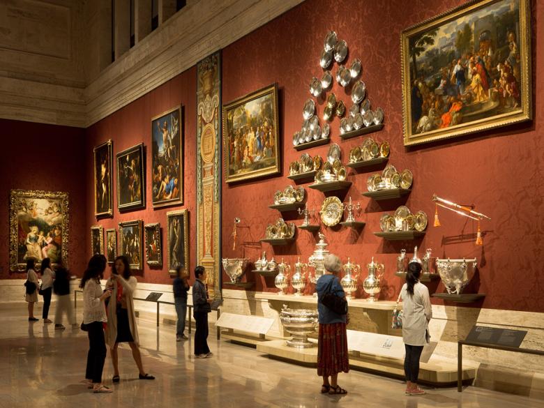 View of gallery wall with large arrangement of Hanoverian silver and various European paintings