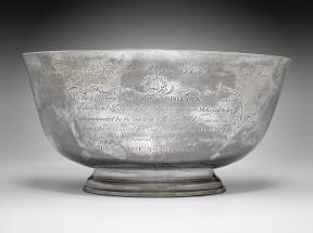 A silver bowl against a gray backdrop.