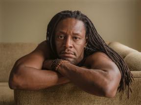 A photo of a man, Herb, lying on a couch resting his head on his crossed arms. 