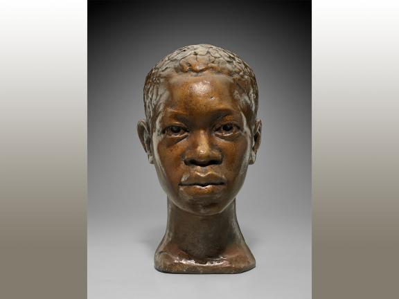 Plaster bust of an young Black man looking straight ahead with a reserved expression.