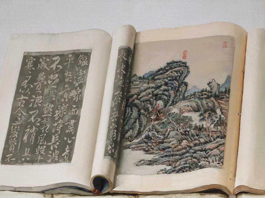 book open to page with Chinese characters and another depicting mountain landscape