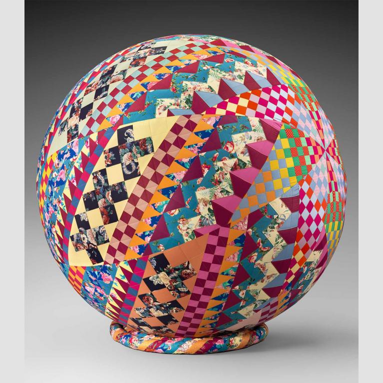 A multi-colored quilt wrapped around a spherical ball